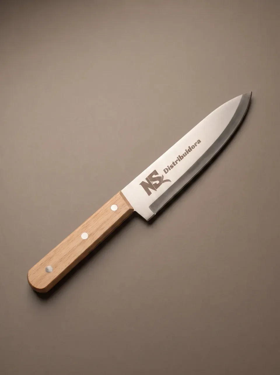 Faca de churrasco de oito polegadas em aço inox, com cabo de madeira clara e três rebites, gravada a laser na lâmina.